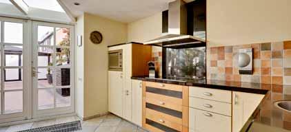 Ruime L-vormige woonkamer met natuurstenen vloer en vloerverwarming.