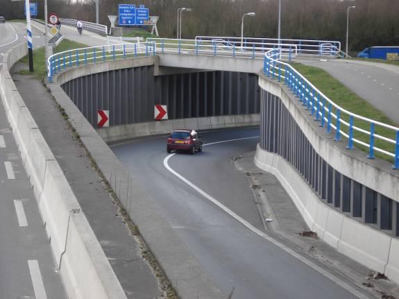 Tussen twee geleiderails door rijd je de oprit op.