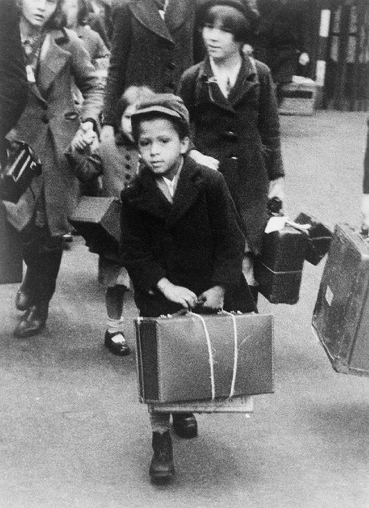 Evacués Foto van een kleine jongen die zijn bagage draagt terwijl hij op 5 juli 1940 samen met een groep andere evacués vanuit Londen naar het platteland vertrekt Drieënhalf miljoen Britten,