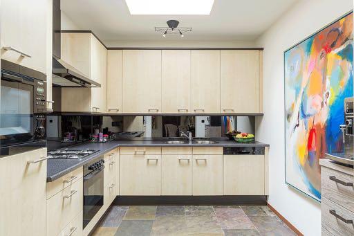 De praktische open keuken heeft een leistenen vloer en door middel van een lichtkoepel veel