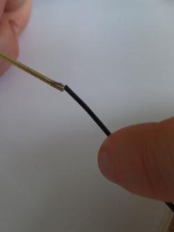 1) Draai de koperdraadjes van het gestripte stuk van de zwarte draad uit het contactstuk tot een streepje.