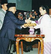 c.) #De volgorde is: b, a, c. a. President Suharto bezoekt de Verenigde Naties, 1970. b. President Soekarno op bezoek bij Fidel Castro van Cuba, 1960. c. Mevrouw Megawati Sukarnoputri neemt de symbolen van het presidentschap in ontvangst, 2001.