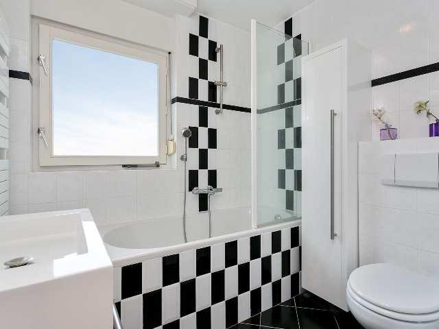 1E & 2E VERDIEPING BADKAMER Moderne betegelde badkamer in lichte kleurstelling.