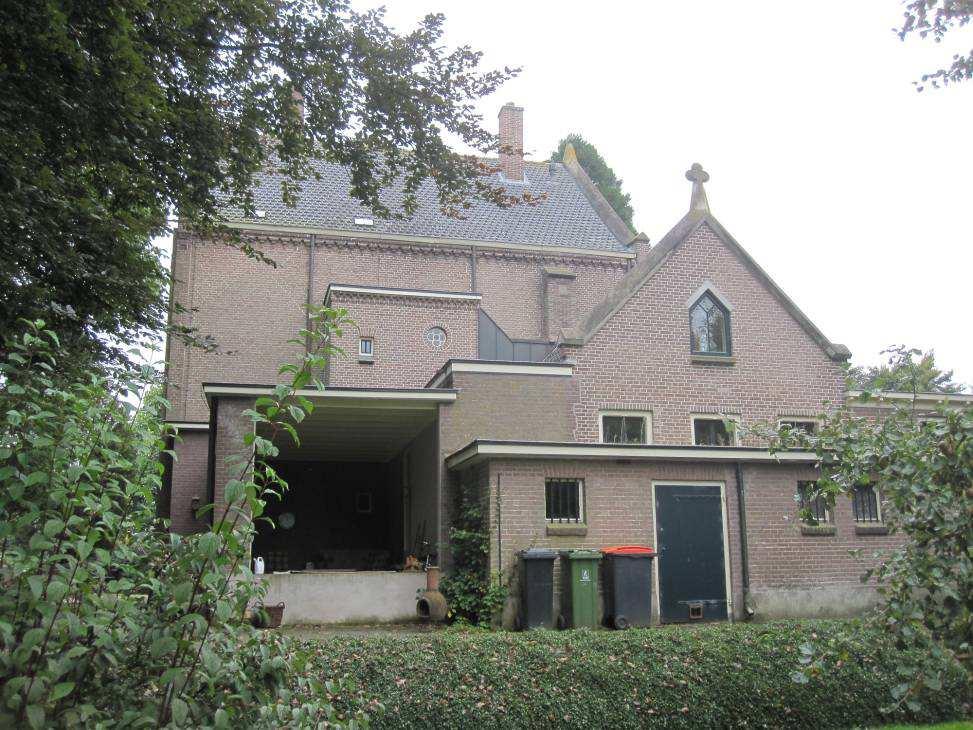 Afbeelding 3: Overzicht van de achtergevel van voorhuis, achterhuis, veranda en lage gang richting de sacristie van de kerk.