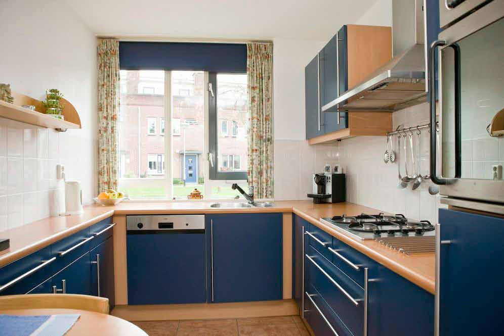 De keuken beschikt over een keukenblok in hoekopstelling met boven- en onderkasten, anderhalve