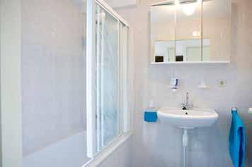 De badkamer beschikt over een ligbad met douchegarnituur en een wastafel.