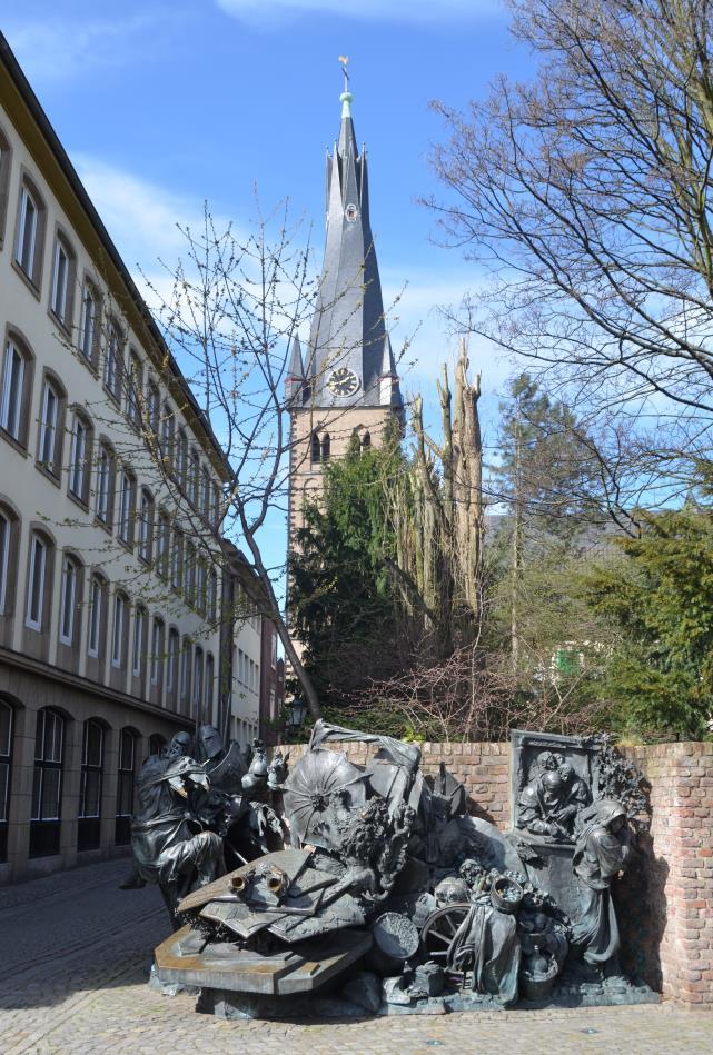 Foto 2 1. Hoe heet de kerk die je op de foto ziet? 2. Wat heeft het kunstwerk op de foto met Düsseldorf te maken? Bekijk hiervoor het kunstwerk goed! 3.