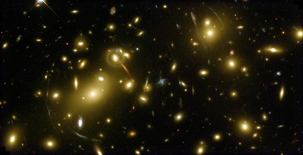 Figuur 7.2 Voorbeeld van een zwaartekrachtlens: de rijke cluster van sterrenstelsels Abell 2218 afgebeeld door de ruimtetelescoop Hubble Space Telescope in 1999. Afbeelding: NASA/ESA, A.
