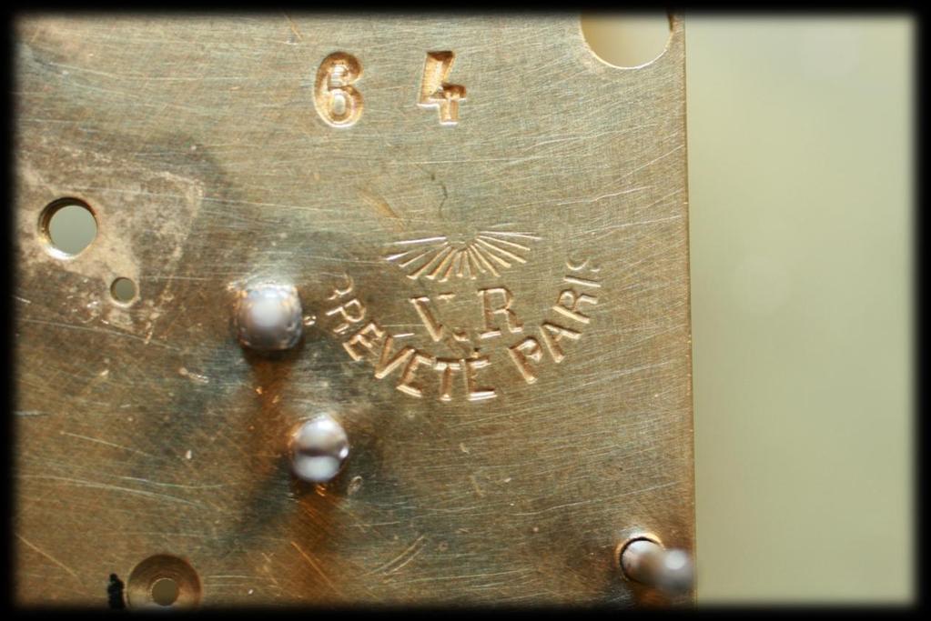 Franse pendule met Speelwerk en bewegend mechaniek (Spaanse danseres) Markering op het uurwerk schijnende zon met daaronder V.R. en BREVETTÉ PARIS los hiervan de nummers 64 en 27707.