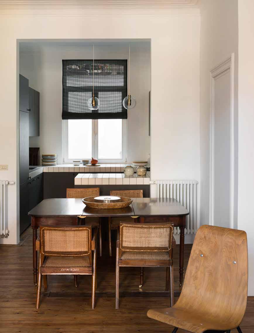 76 INTERIEUR/NO.2 MAART 2015 EH&I IN DE EETKAMER EEN VINTAGE HOUTEN TAFEL MET VIER OFFICE CANE CHAIRS UIT 1954 VAN PIERRE JEANNERET.