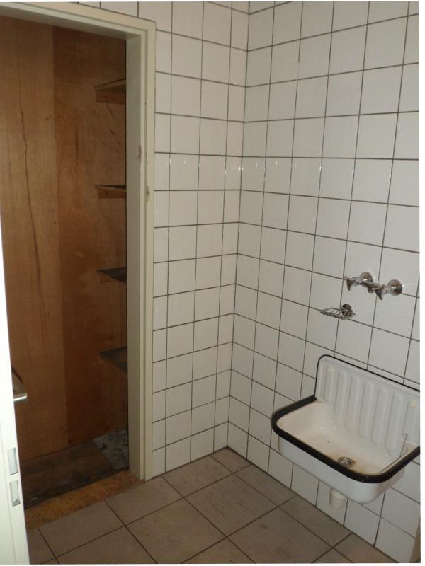 Het voorportaal van de toiletruimte is voorzien van vol betegelde wanden en een tegelvloer.