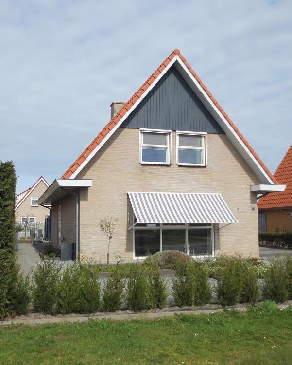 Deze moderne vrijstaande woning (2008) ligt aan de oostzijde van het dorp Nes op een royale kavel van 524