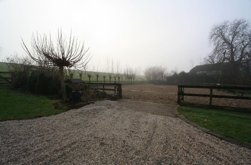 Ligging en indeling Tuin De riante voortuin heeft veel grasland en een paardenbak met drainagesysteem ook kunt u hier gemakkelijk meerdere auto's parkeren op eigen terrein.