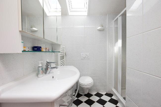 De badkamer is uitgerust met douche, wastafel met meubel en hangend toilet.