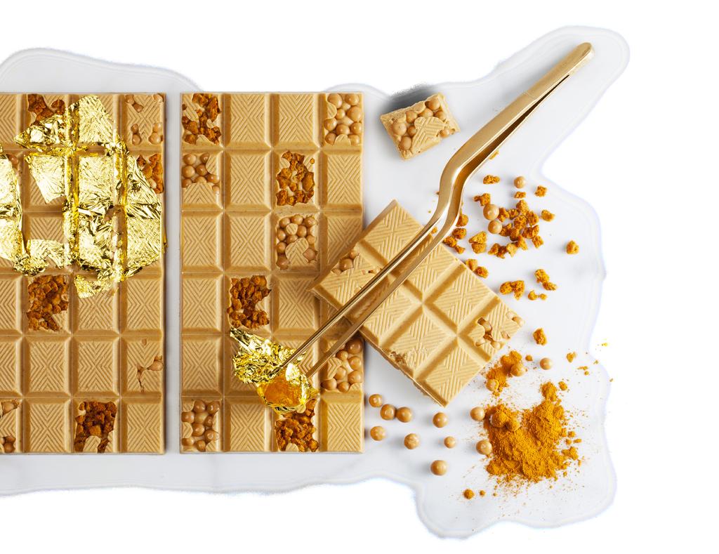 Giet evenredige laagjes Gold- en witte chocolade op elkaar in een maatbeker.