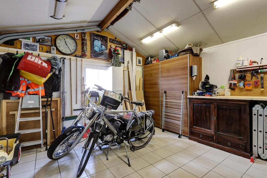 GARAGE - De ruime garage bevindt zich aan de achterzijde van de woning. - Van binnenuit te bereiken via de hal/bijkeuken.