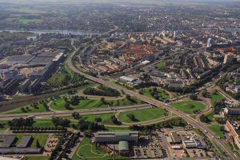 De luchtfoto van de A2-passage Maastricht is genomen richting het noordoosten. Links de woonbuurt Wyckerpoort. In het midden het grootschalige voormalige KPN-gebouw.