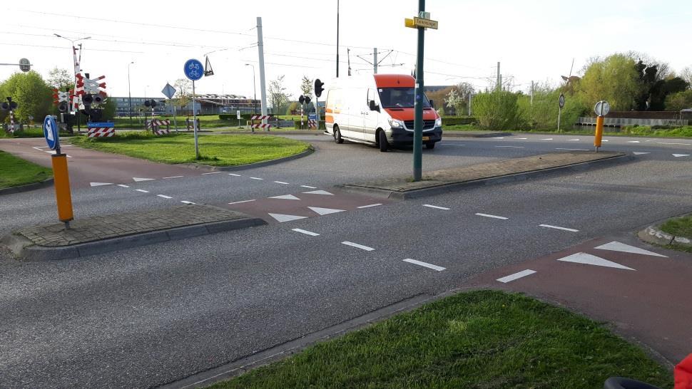 Fietsers, komend vanuit Nieuwegein, snijden kruising af de Beneluxweg op. Fietspad achter bushalte lijkt te smal aangelegd.