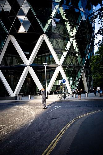 Laat ook wat van de omgeving zien. Het gebouw 30 St Mary Axe, bekend als De Augurk, in Londen heeft een kantoorfunctie, de zakenlieden die er omheen lopen geven hier een idee van.