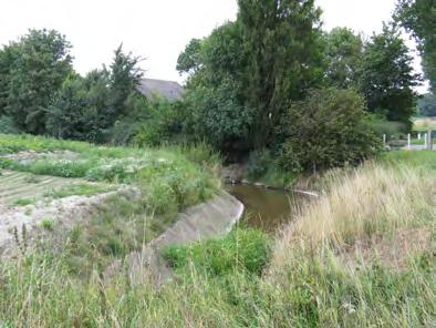 Aan de noordzijde van de N253 ligt de passage nabij een woonhuis waarbij de watergang de perceelgrens vormt.