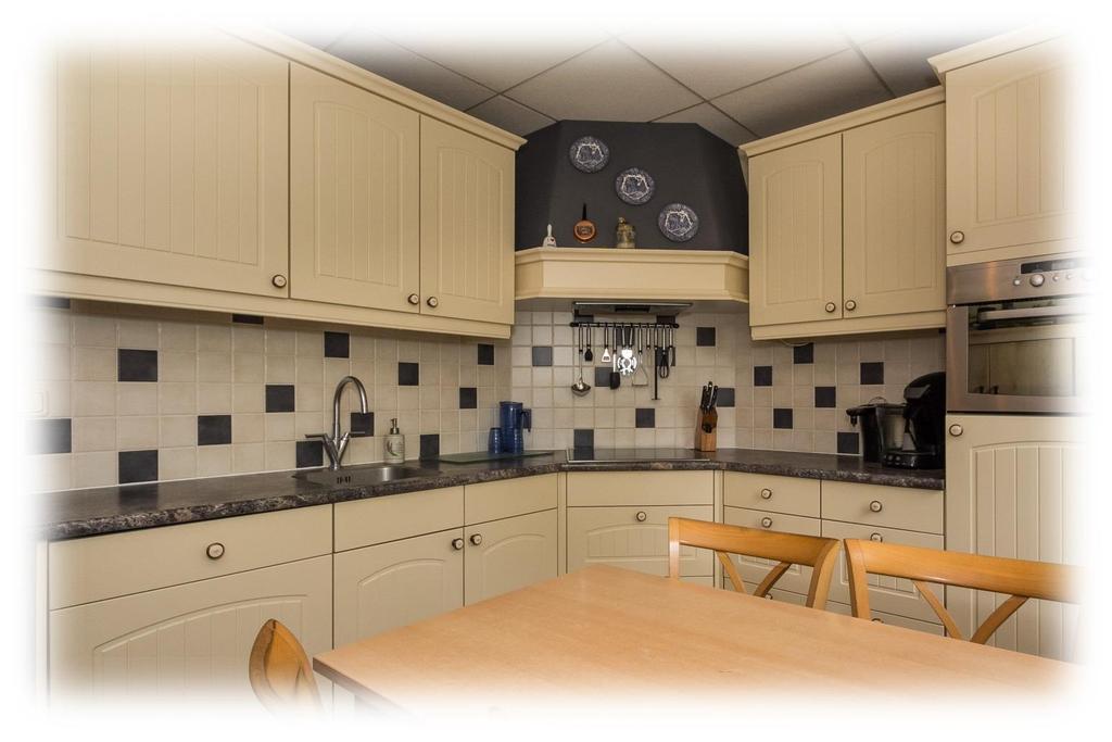 EETKEUKEN Besloten keukenruimte met een heerlijke hoekopstelling in landelijke stijl, afgewerkt in een vanillekleur.