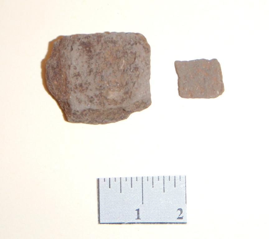 Tussen het houtskool zit een verkoolde schub van een dennenappel (zie afbeelding 5). Mogelijk dateert deze schub uit de prehistorie. De overige vondsten dateren uit de.