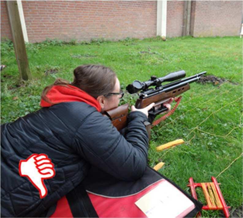 mag de achterkant van de kolf de grond raken. De voorkant van het geweer, hamster of pistoolgreep, mogen de grond niet raken.