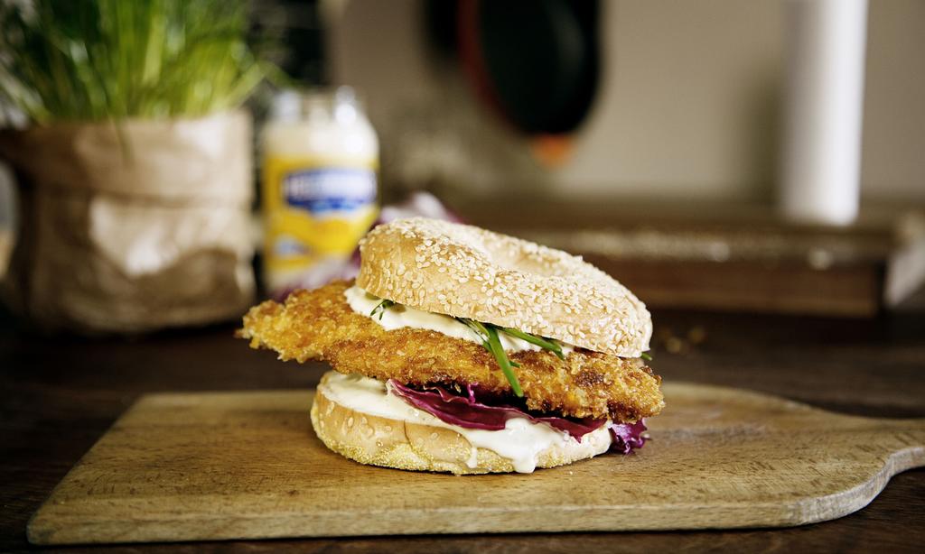 THE CRUNCHY CHICKEN BURGER 2 kipfilets (125 gram) 2 eieren 100 gram cornflakes 100 gram broodkruimels 30 gram margarine of olie Romeinse sla 1 limoen 2 bagelbroodjes zout (optioneel) 1.