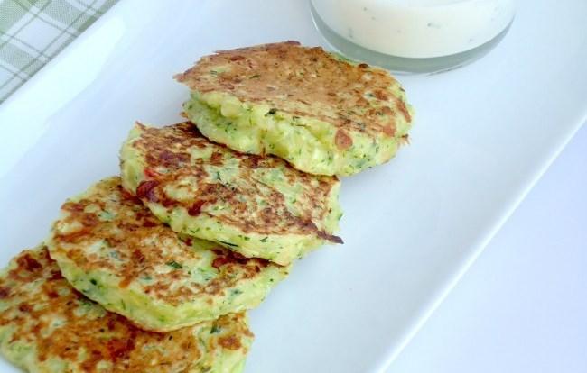 Joske Bogaerts Courgettepannenkoekjes Courgette Zout Fetakaas en parmezaanse kaas Eieren Melk Bloem Sjalotjes Griekse yoghurt Munt Courgettes raspen en besprenkelen met zout.