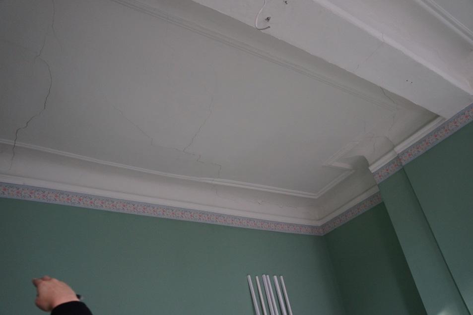 rechterbovenhoek van de deur, loopt verder op het plafond (foto 18)