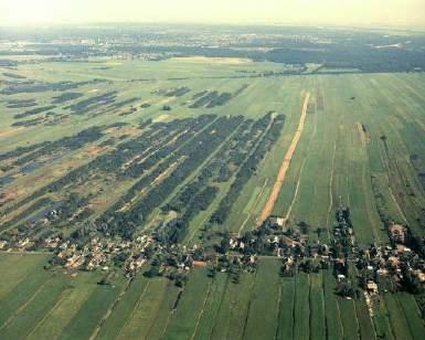 <foto s: Delta-Phot Luchtfotografie, 1979> Vorm en afmeting van petgaten wisselen door vroegere variatie in lokale vervening. Lokaal bleef op ondiep gelegen dekzandruggen vervening uit.