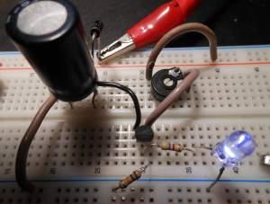 geleiden. Wanneer de voeding werkt wordt ook de condensator opgeladen. Valt de voeding weg, dan gaat de transistor in verzadiging. De condensator kan geen stroom leveren door R1 want de diode spert.