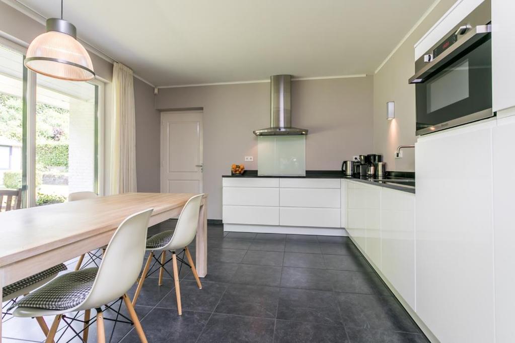 De ruime luxe keuken (16m²) is voorzien van inrichting en apparatuur: RVS afzuigkap, 4 pits keramische kookplaat