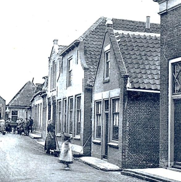 Kerkstraat A-270. Na 1957 Hoge Kerkstraat 24. Eens een mooie bakkerij (naast de vrouw in klederdracht), nu een kale garage. Ca.