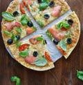 Flammkuchen met zalm Voorbereiding: 5 minuten Bereiding: 10 minuten - 1 wrap - 40-50 g plakjes gerookte zalm - 3 zwarte olijven, gehalveerd - 1 tomaat, in dunne plakjes - 1 el zuivelspread kruiden