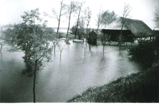Foto genomen vanaf de Boomdijk door J.A. Geluk in 1944. Hofstede Vrouw Belij, schuur en knechtswoning tijdens de inundatie. Karel van der Klooster, zn.