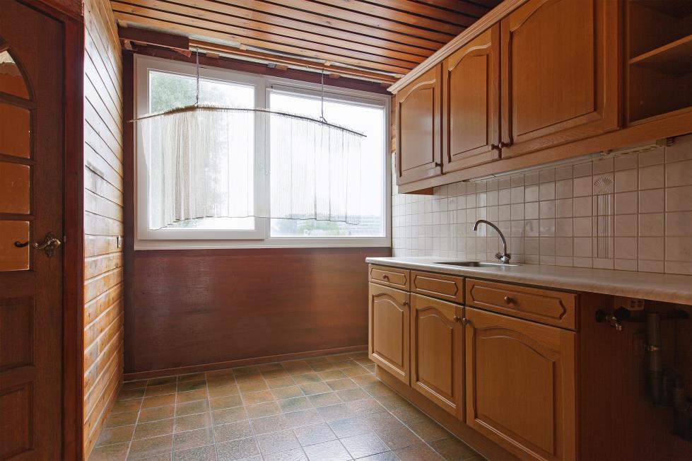 Keuken Aan de galerijzijde gelegen keuken voorzien van een keukenblok met houten keukenkastjes en een kunststof aanrechtblad