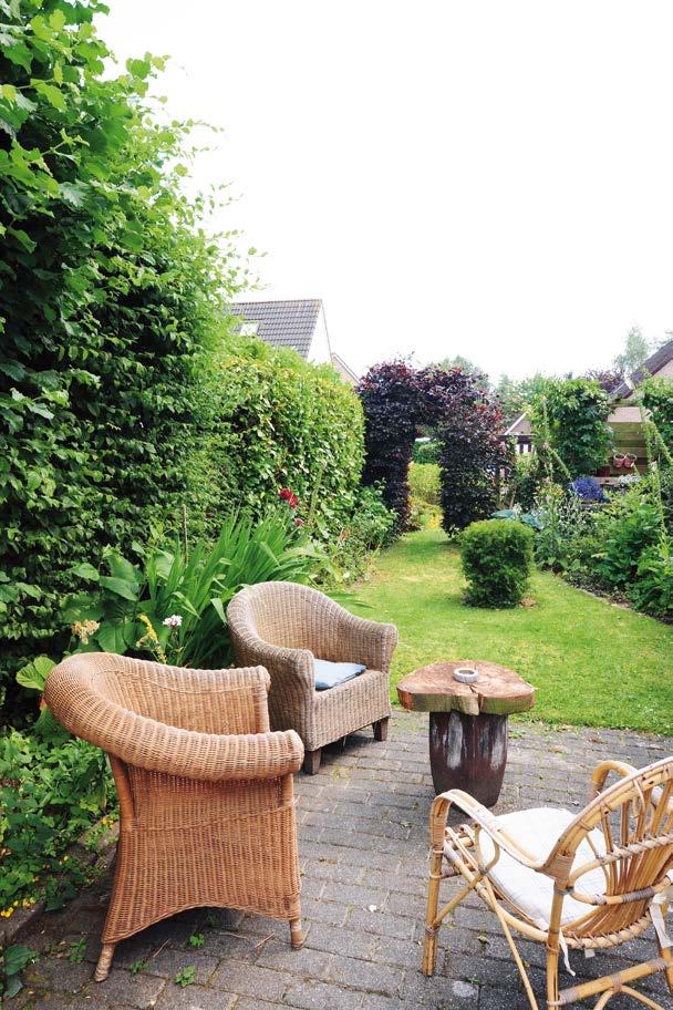 Je ziet verschillende zithoekjes als je langs de smalle paadjes in de tuin loopt. In de tuin zijn stukken oud hout verwerkt.