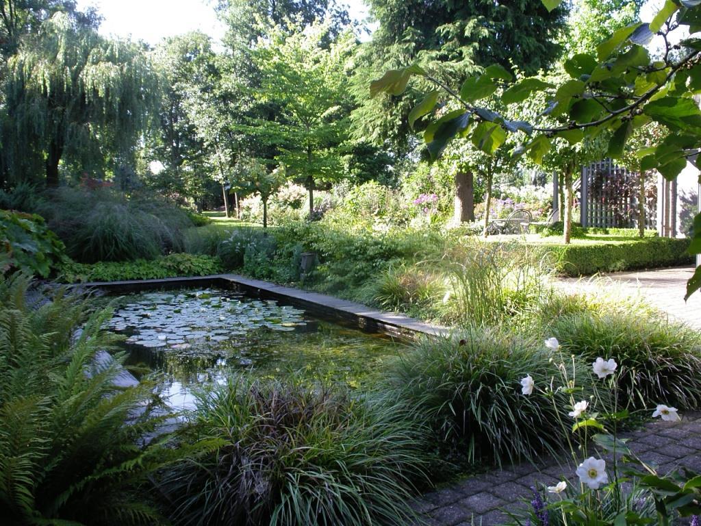 TUIN De parkachtige, mooi aangelegde vrij gelegen tuin is gesitueerd op het zuidoosten.