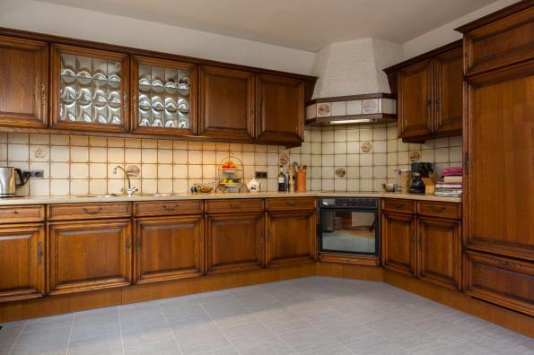 De keuken is voorzien van veel kastjes waardoor er veel opbergruimte aanwezig is, diverse gedateerde apparatuur zoals onder andere een fornuis, afzuigkap en koelkast.