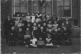 Het verhaal van Joela (Julia) de Lange, onderduiken en overleven Op deze klassenfoto uit circa 1920 staat een bijzonder Joods meisje, Joela (Julia) de Lange (het meisje links onderaan naast het bord,