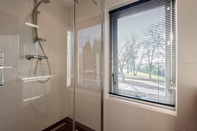 De stijlvolle badkamer is voorzien van een moderne betegeling. Douchen wordt een weelde in de extra brede douchecabine met glazen douchewand en thermostaatkraan.