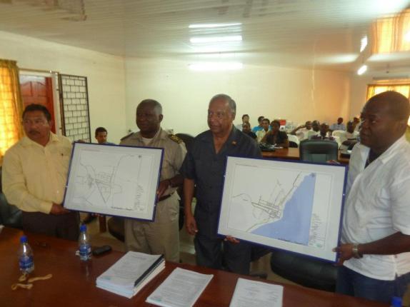 Foto boven: Overdracht door het DLGP-projectbureau van projecten en documenten aan de Districts-Commissaris van Marowijne op het gebied van bestrating van wegen en ontwatering van woonwijken.
