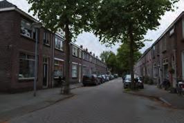 Aan de Van der Woudestraat is een woongebouw gerealiseerd met garages rond een voorplein en daarboven woningen ontsloten via een overdekte galerij.