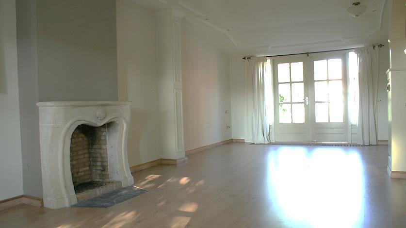 De woonkamer is afgewerkt met een laminaatvloer, deels stucwerk, deels lambrisering
