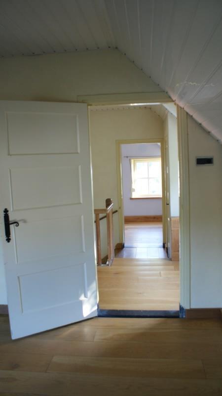 Slaapkamer 1 is afgewerkt met een grenen houten vloerafwerking, spachtelputz wandafwerking en een