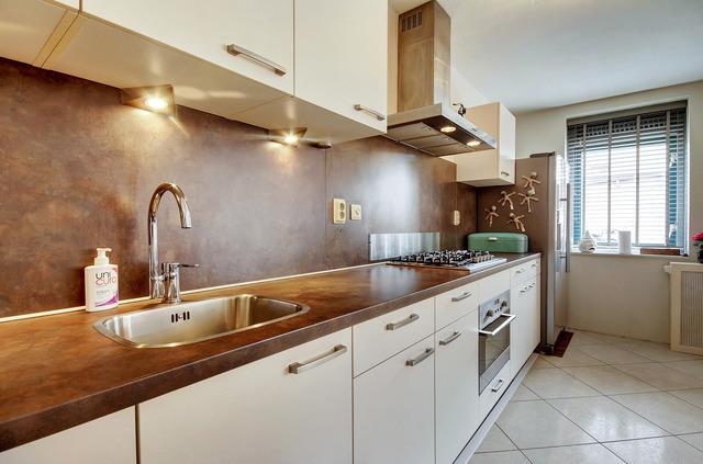 De zeer lichte en ruime woonkamer met open keuken (2015) en vloerverwarming heeft een praktische indeling.
