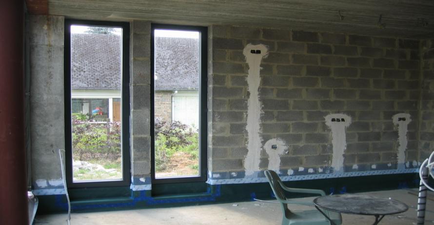 Aansluiting betonvloer met muur en raam