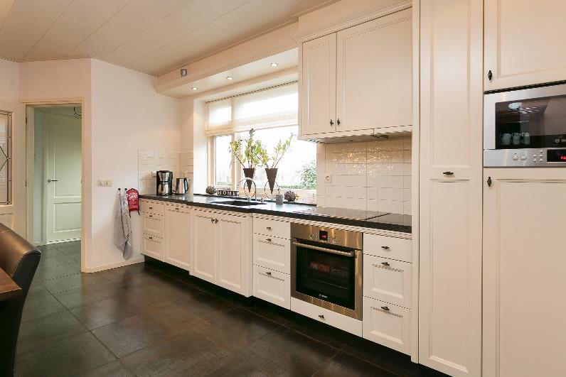 De keuken beschikt over diverse inbouwapparatuur zoals een oven, magnetron,