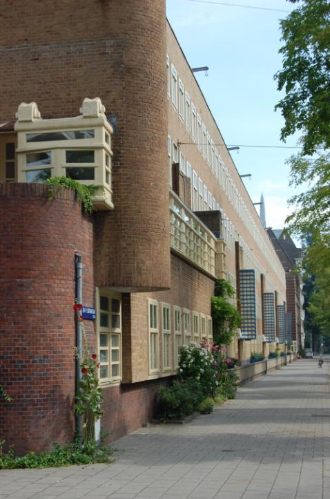 De Harmoniehof uitfietsen, Daniel de Langestraat oversteken tot aan de Roelof Hartstraat. Oversteken en linksaf tot aan de Bartolomeus Ruloffstraat fietsen. Sta even stil op het trottoir.
